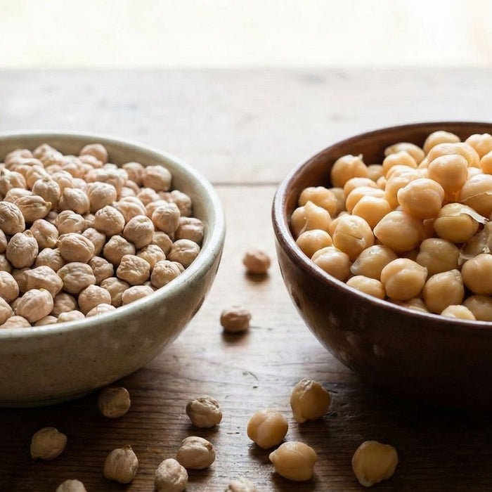 Dried chickpeas and cooked chickpeas in bowls side by side