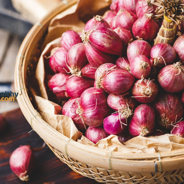Basket full of red onions ready for kitchen use.