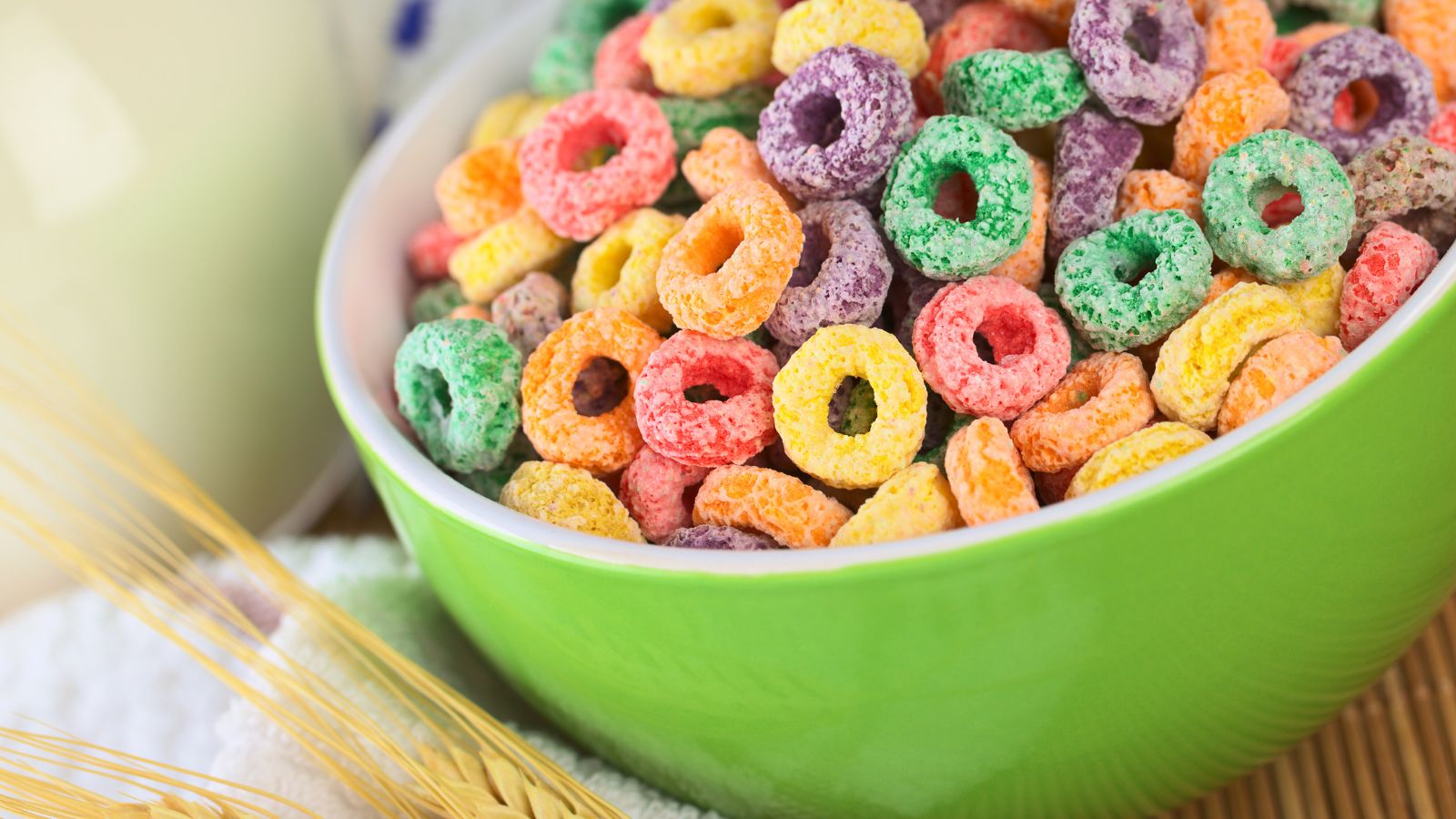 Green bowl filled with colorful fruit-flavored breakfast cereal loops