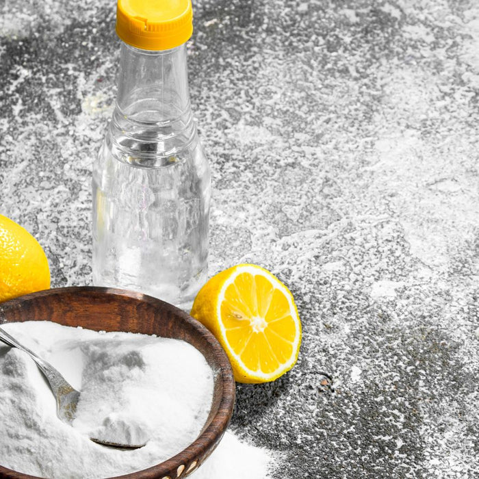 Baking soda with lemon and vinegar on a textured countertop.