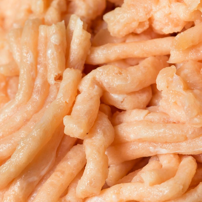 Raw ground turkey meat in close-up texture view.