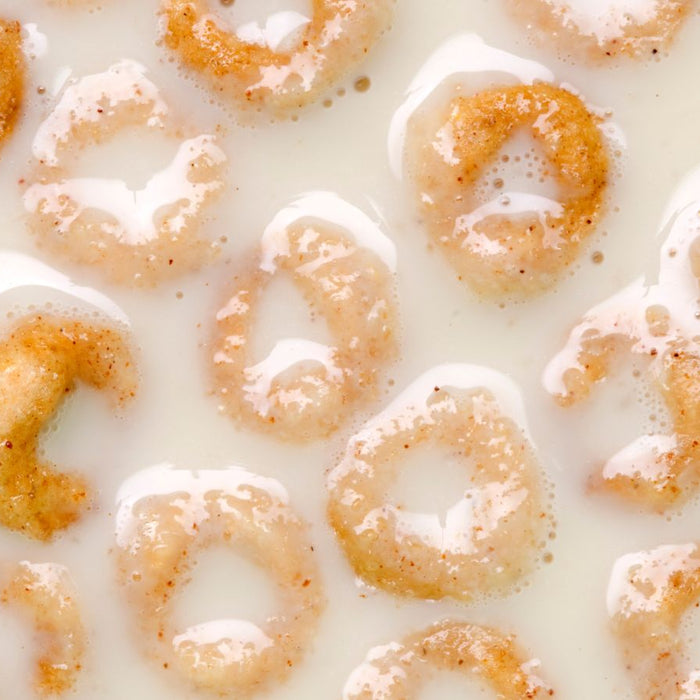 Cinnamon-flavored cereal rings soaked in milk with a glossy texture