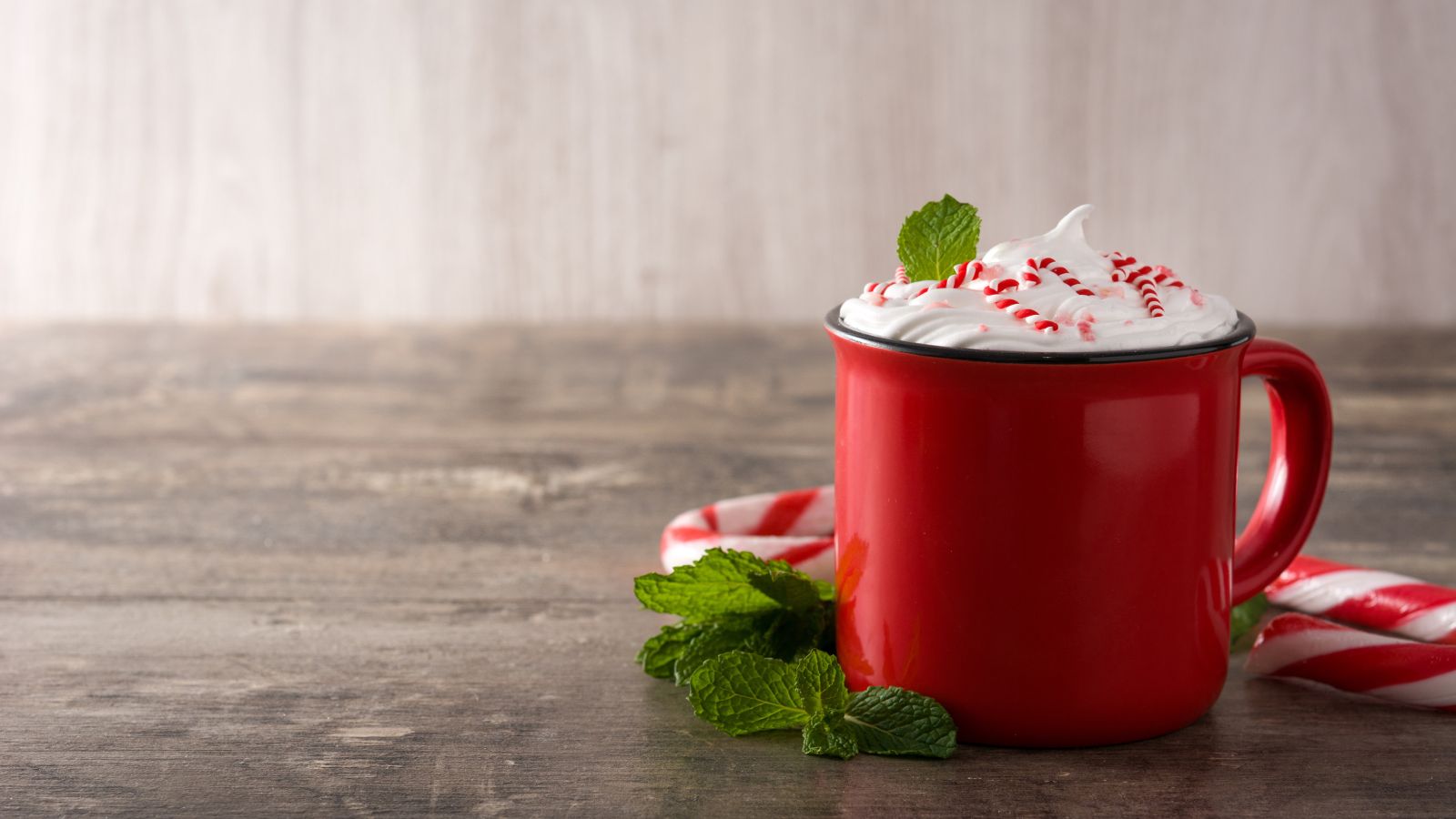 Red mug with peppermint whipped cream and mint leaves