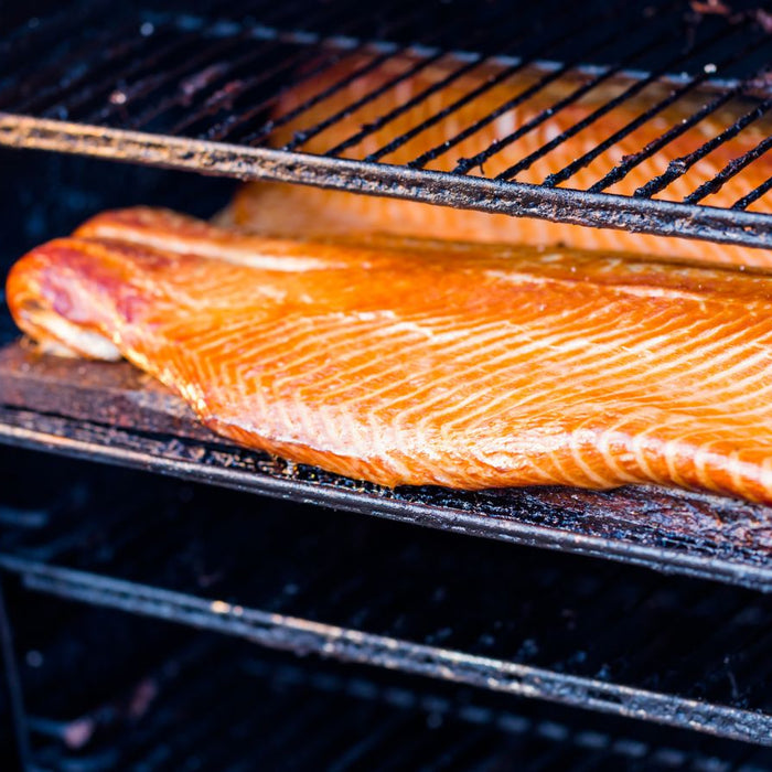 Smoked salmon on grill rack with golden-brown glaze.
