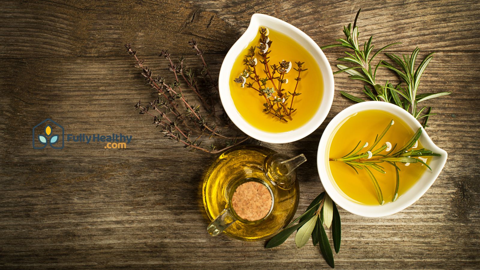 Bowls of olive oil with herbs on wooden table for healthy cooking.