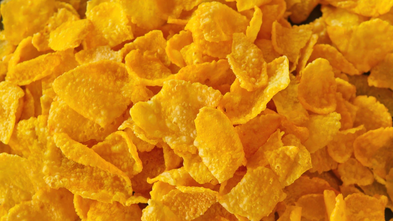 Close-up view of golden cornflakes breakfast cereal piled together