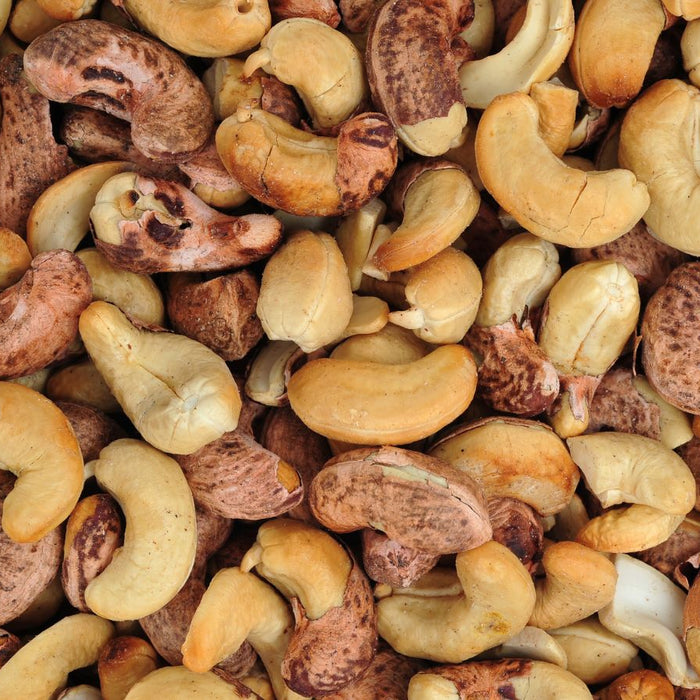 Cashew nuts with shell partially removed in a pile.
