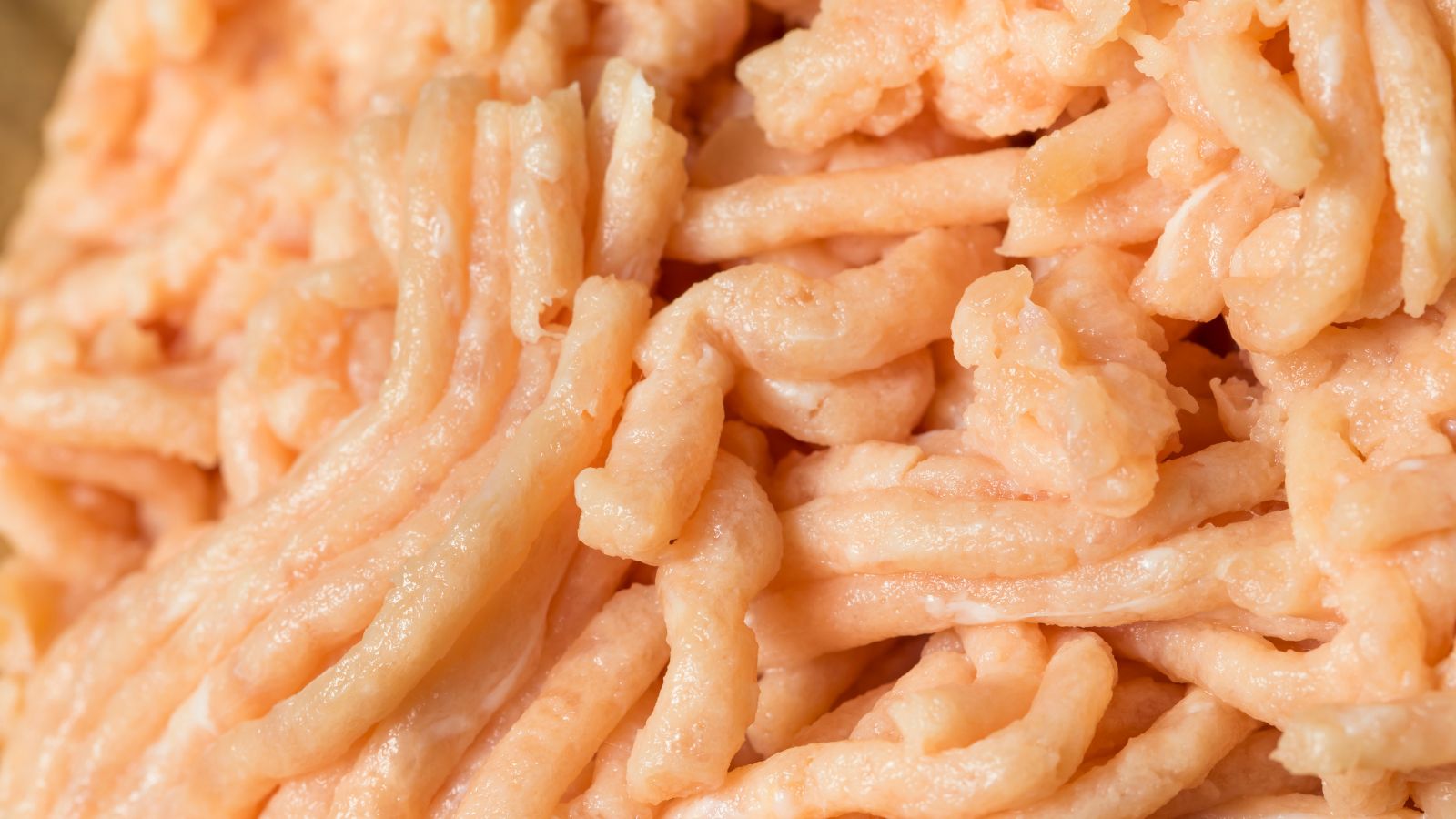 Raw ground turkey meat in close-up texture view.