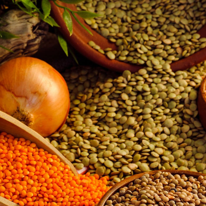Lentils and onion on table with wooden scoop and clay bowls