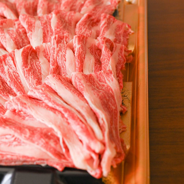 Thinly sliced Wagyu beef arranged in plastic tray.