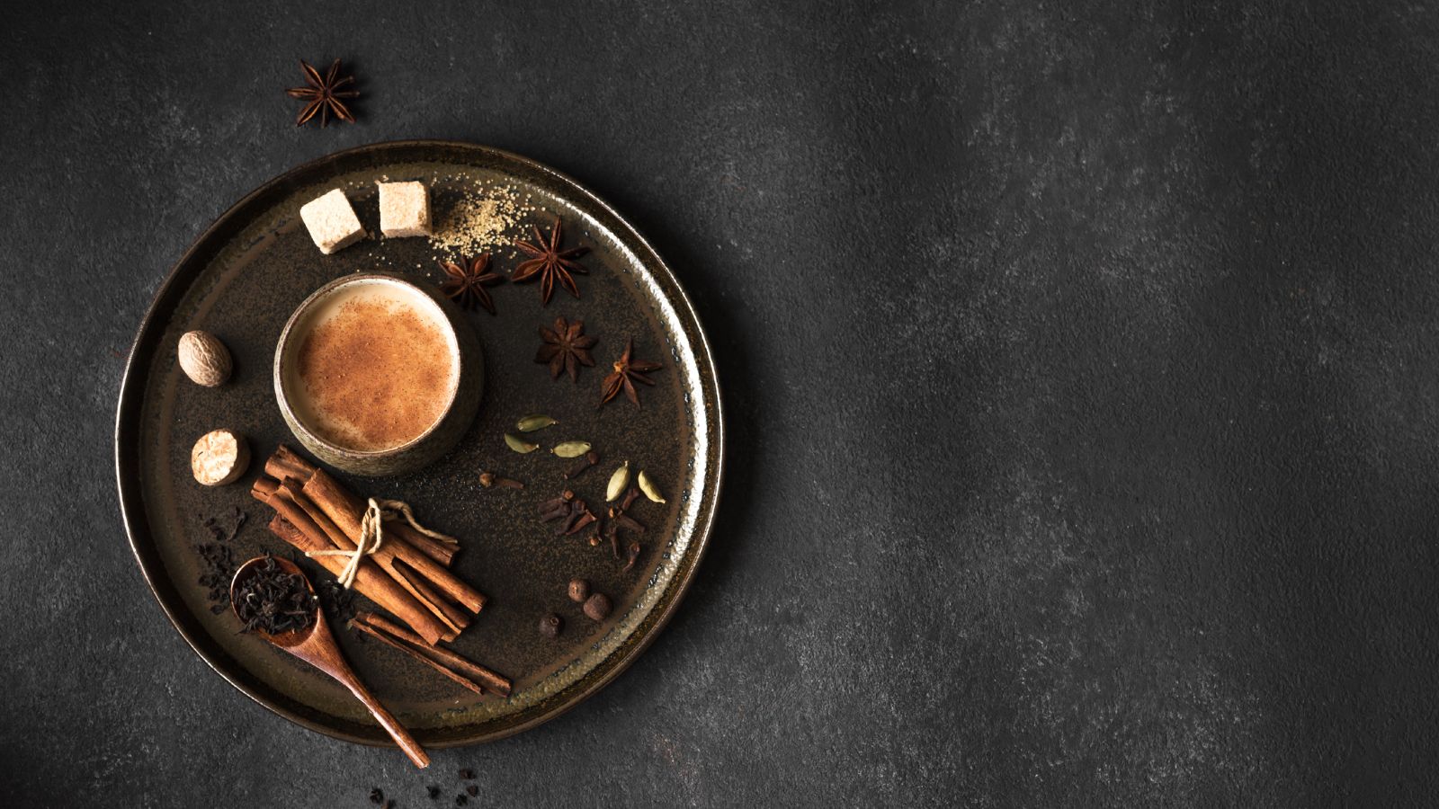 Spiced chai latte in rustic cup with cinnamon, cardamom, and star anise