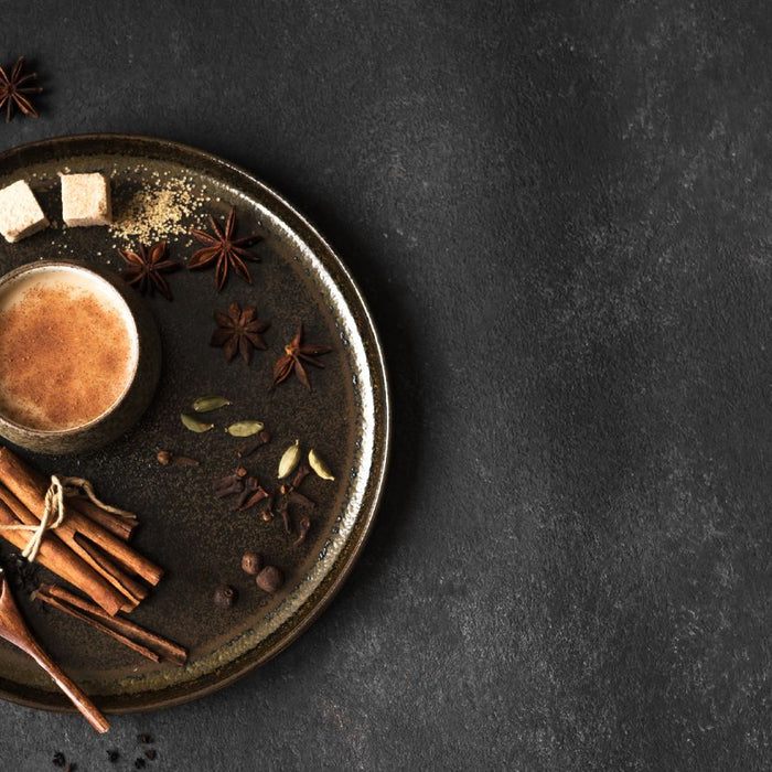Spiced chai latte in rustic cup with cinnamon, cardamom, and star anise