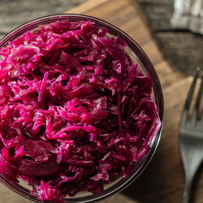 Bowl of sauerkraut on a wooden cutting board.