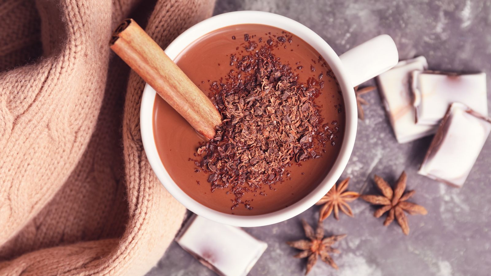 Mug of thick hot chocolate with cinnamon stick and chocolate shavings