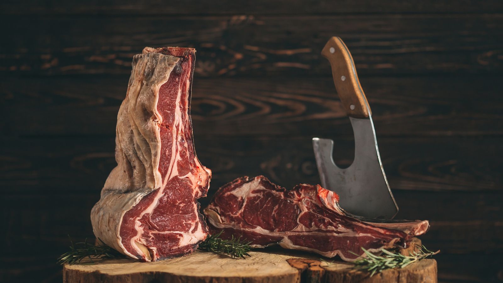 Raw wagyu beef with a cleaver on a wooden chopping block.