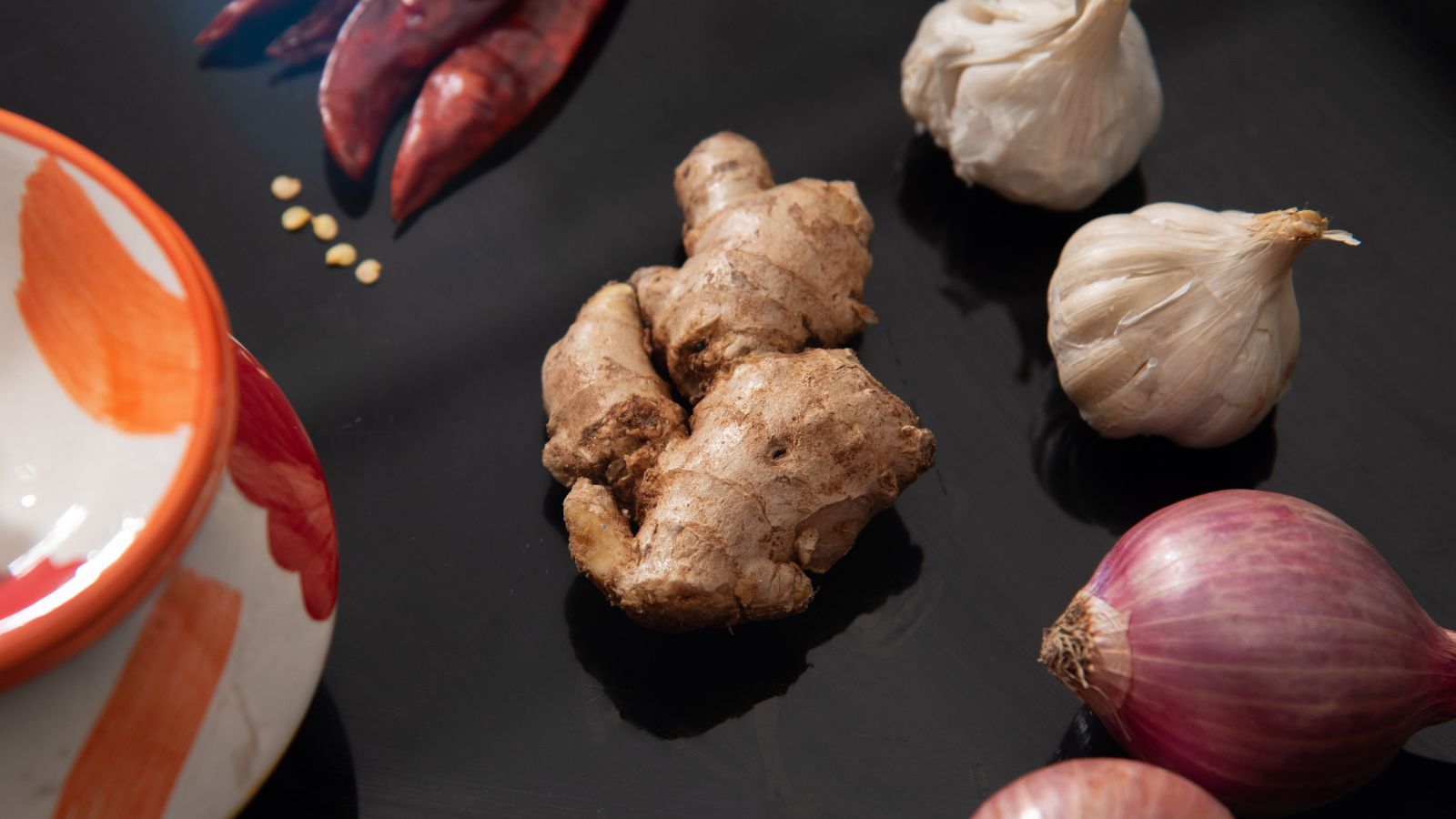 Fresh ginger root with garlic, onion, and dried chili peppers