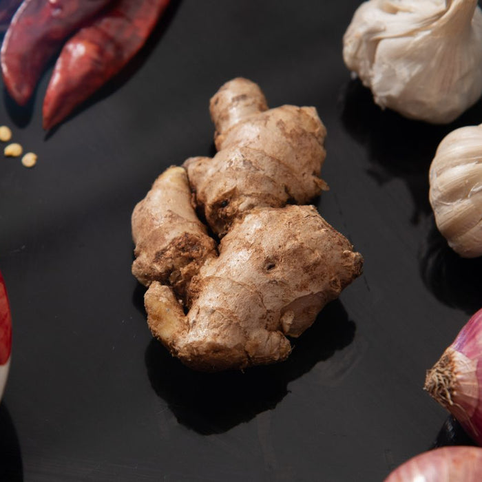 Fresh ginger root with garlic, onion, and dried chili peppers