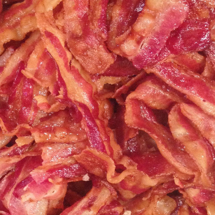 Crispy fried uncured bacon served on a wooden cutting board.