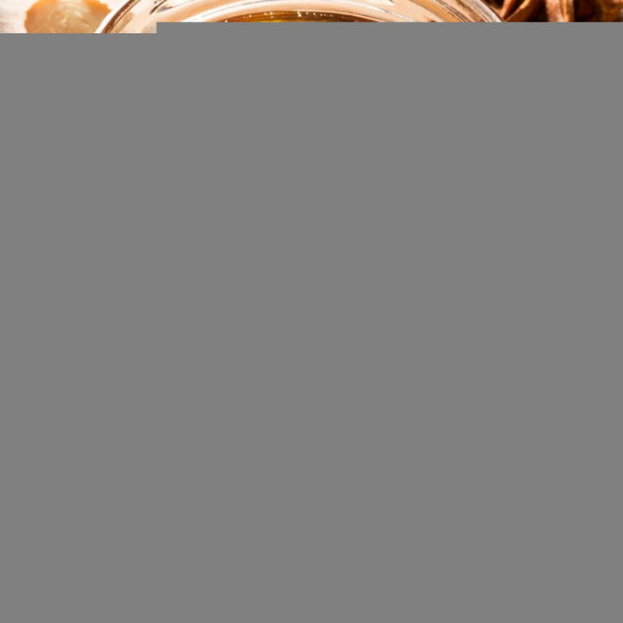 Jar of natural honey with spices like cinnamon, lemon and star anise