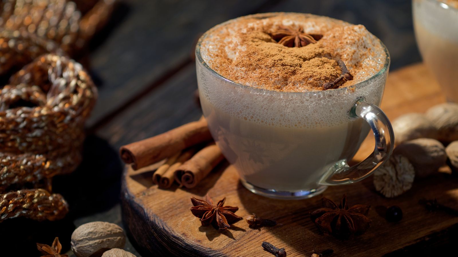 Dirty Chai drink with cinnamon sticks and star anise on wood tray.