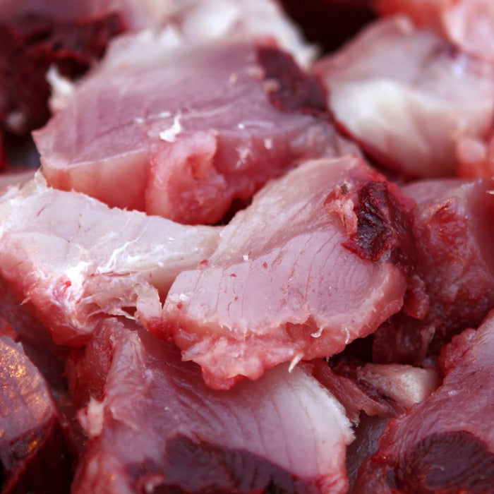 Raw chopped pieces of albacore tuna displayed in a close-up view.