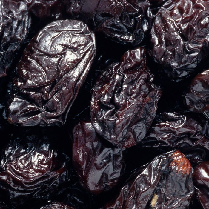 Close-up of wrinkled dried prunes piled together.