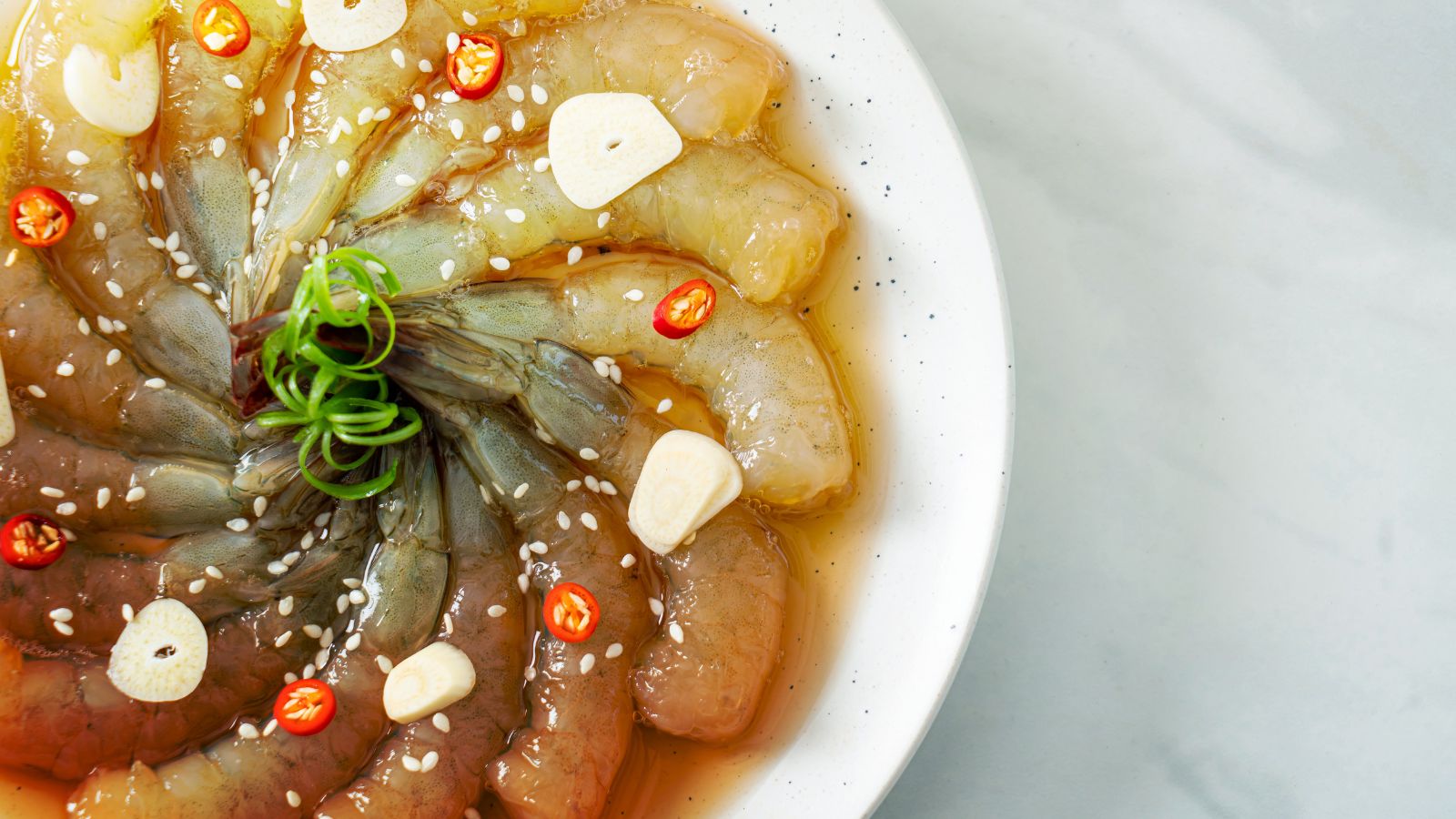 Raw marinated shrimp with garlic slices and chili in fish sauce marinade