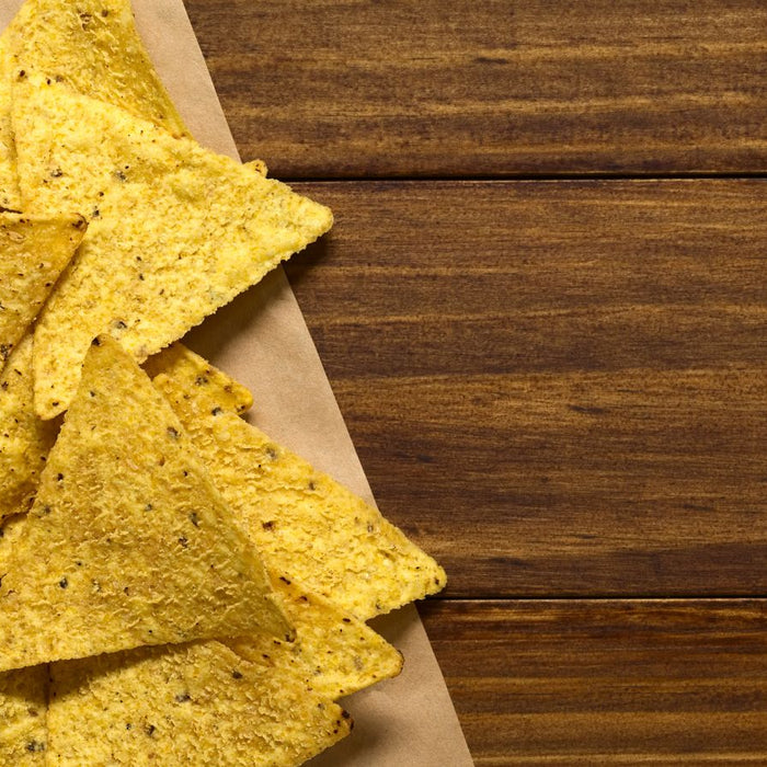 Crispy tortilla chips served with a bowl of green guacamole dip