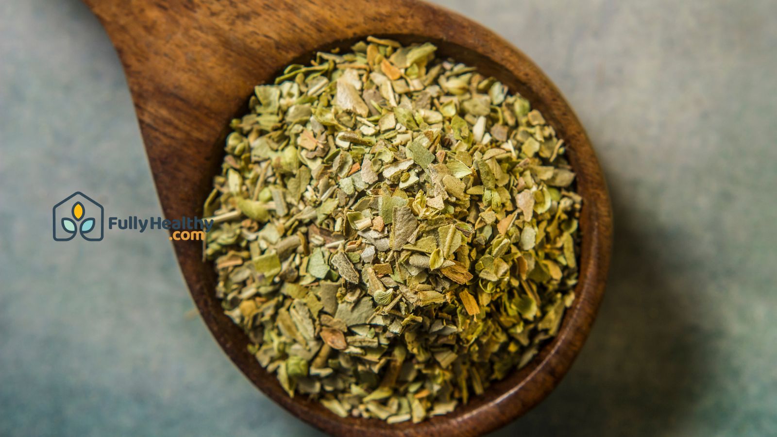 Wooden spoon filled with dried oregano seasoning.