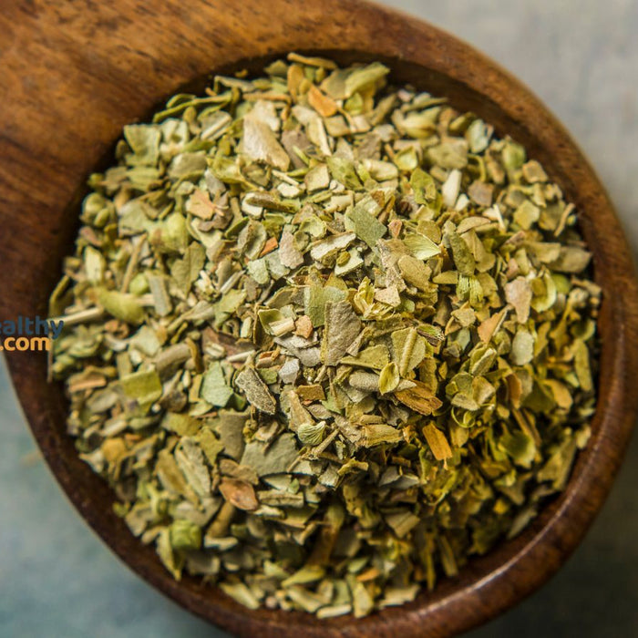 Wooden spoon filled with dried oregano seasoning.