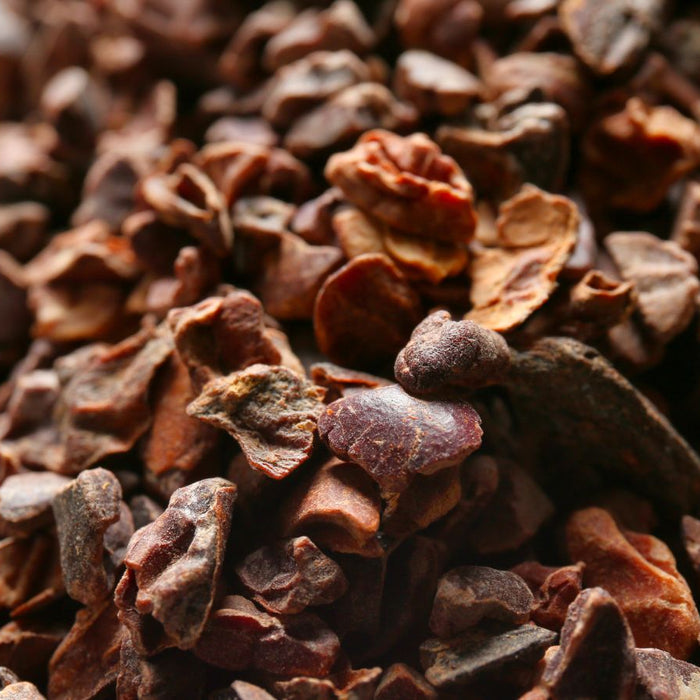 Close-up of raw cacao nibs scattered in a pile.