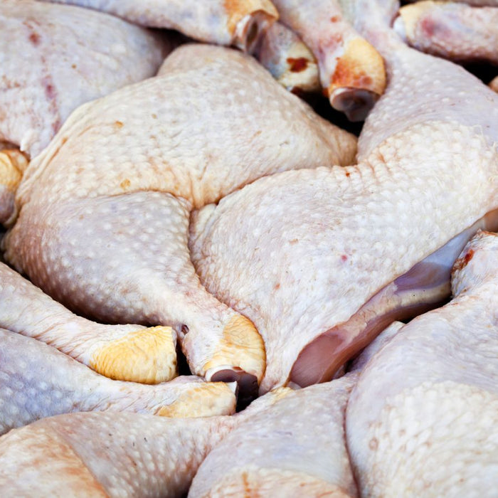 Raw chicken thigh stacked at a market stall