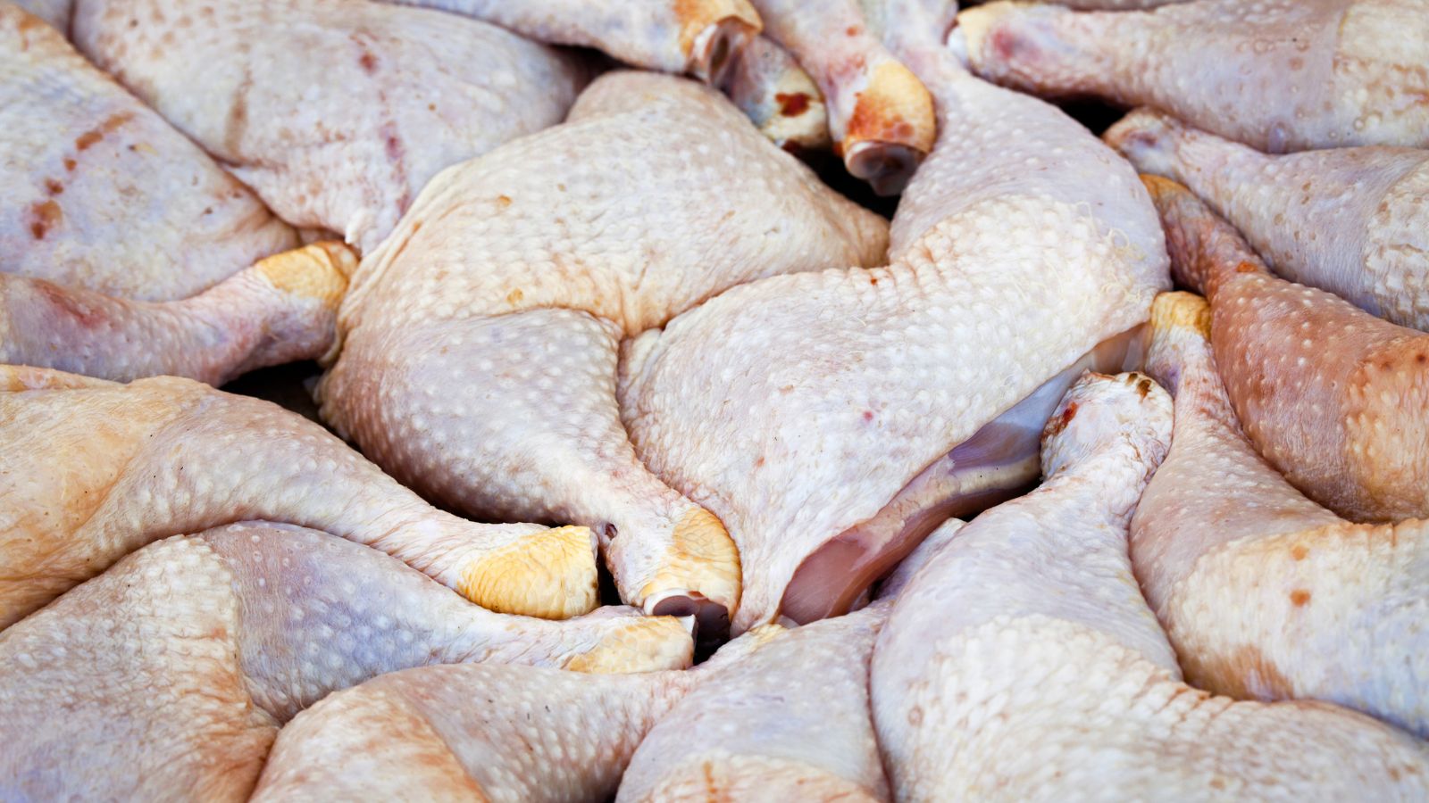 Raw chicken thigh stacked at a market stall