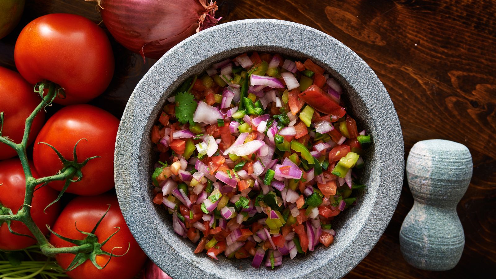 Colorful bowl of freshly made salsa with diced veggies and herbs.