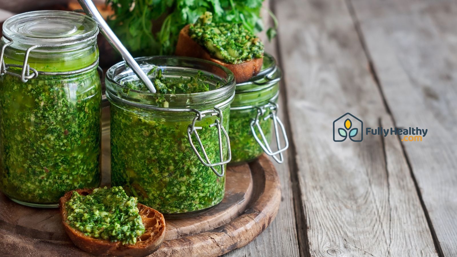 Homemade cilantro pesto in glass jars on rustic wooden table