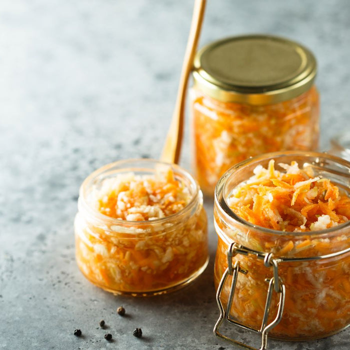 Fermented sauerkraut in jars on concrete surface