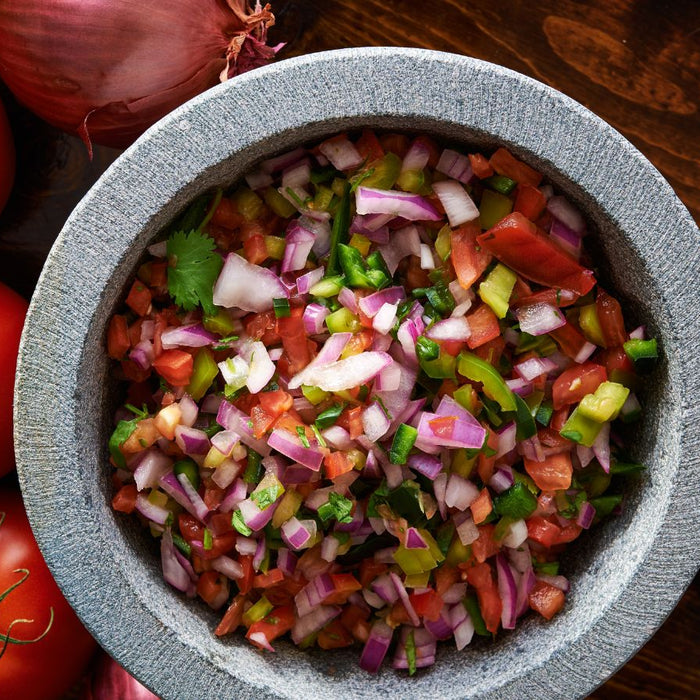 Colorful bowl of freshly made salsa with diced veggies and herbs.