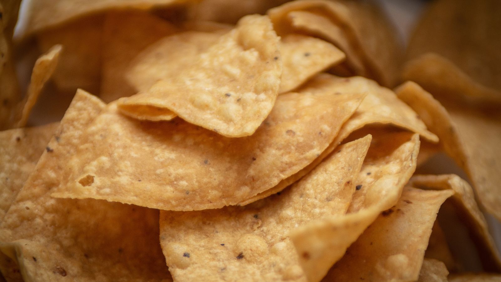 Corn tortilla chips with visible seasoning in a detailed close-up shot