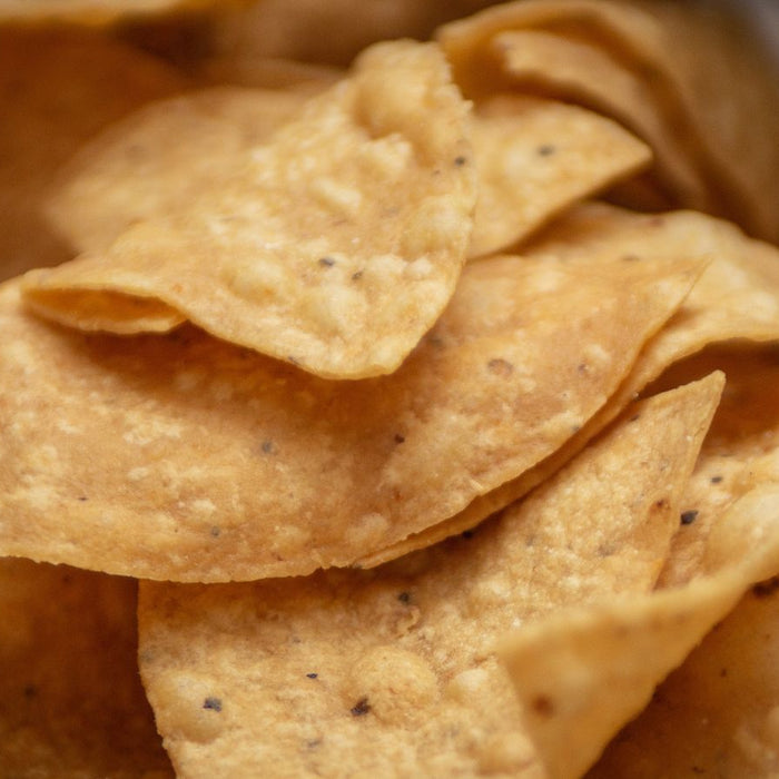 Corn tortilla chips with visible seasoning in a detailed close-up shot