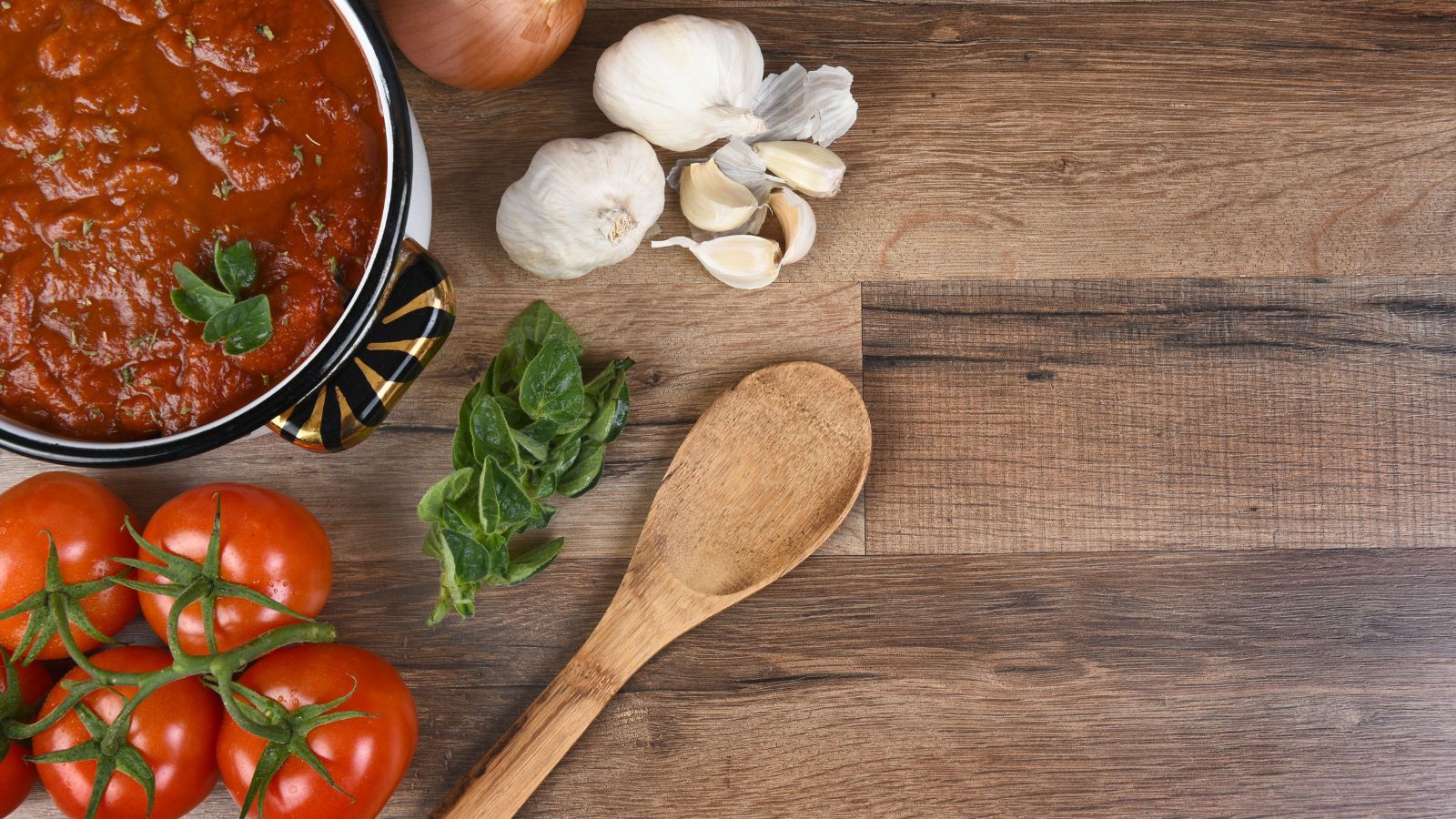 Tomato sauce with garlic, onion, and fresh tomatoes on table.