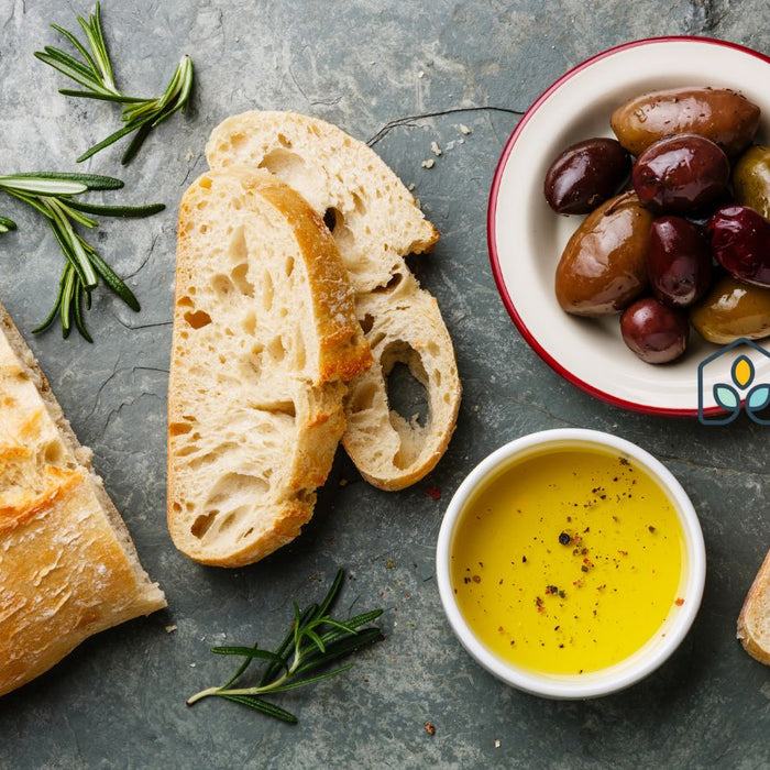 Bread with olive oil and olives on table for healthy Mediterranean meal.