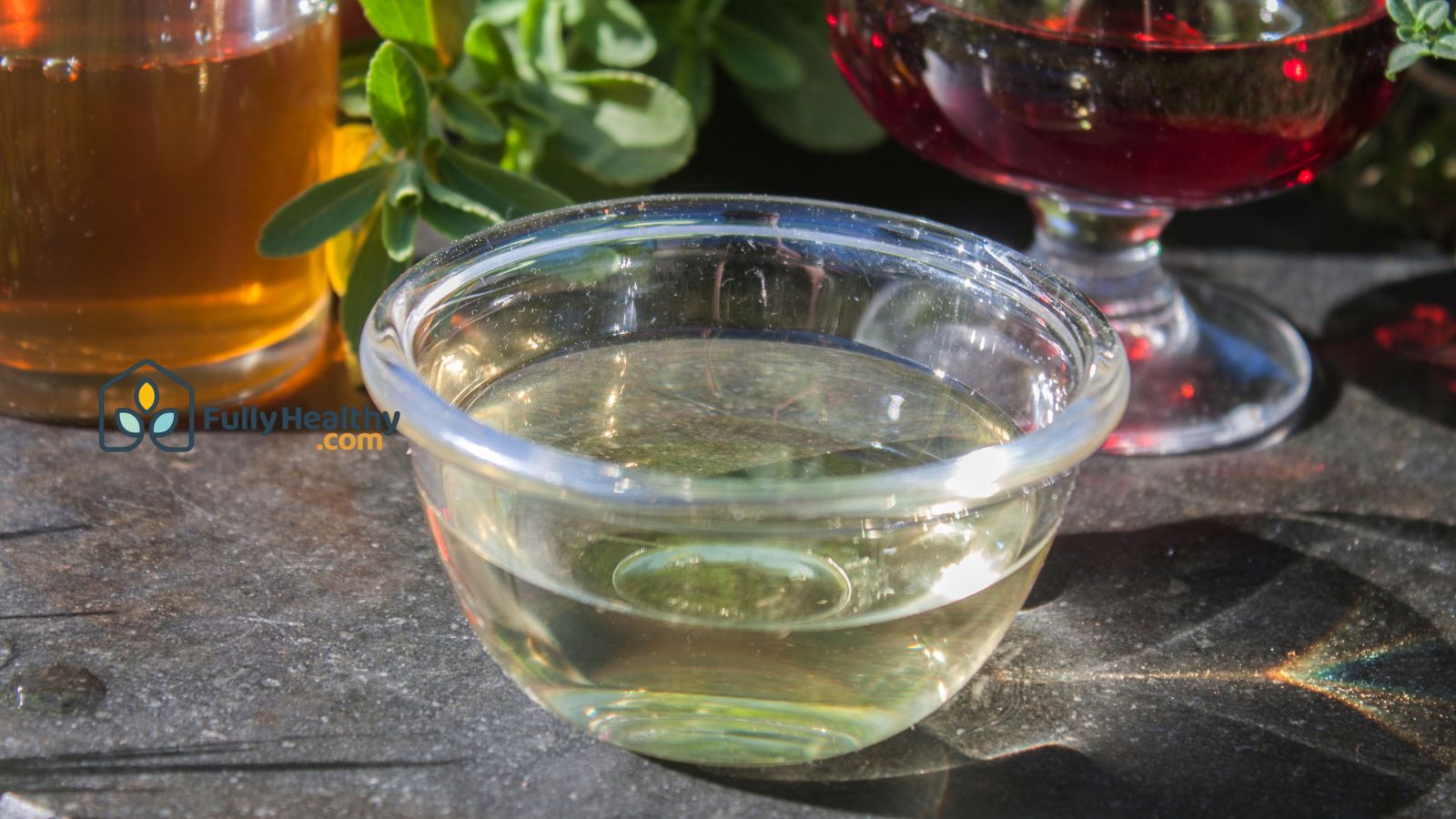 Glass bowl of sherry vinegar with herbs and natural extracts outside