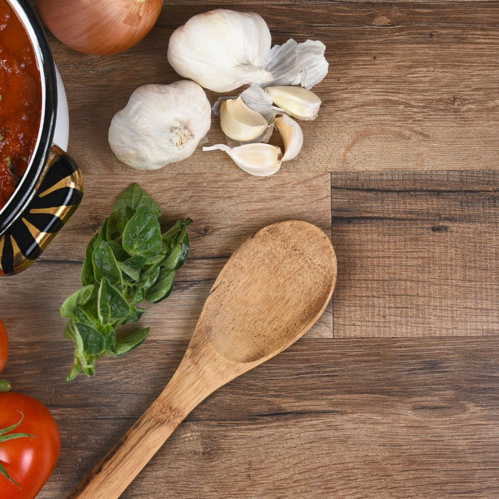 Tomato sauce with garlic, onion, and fresh tomatoes on table.