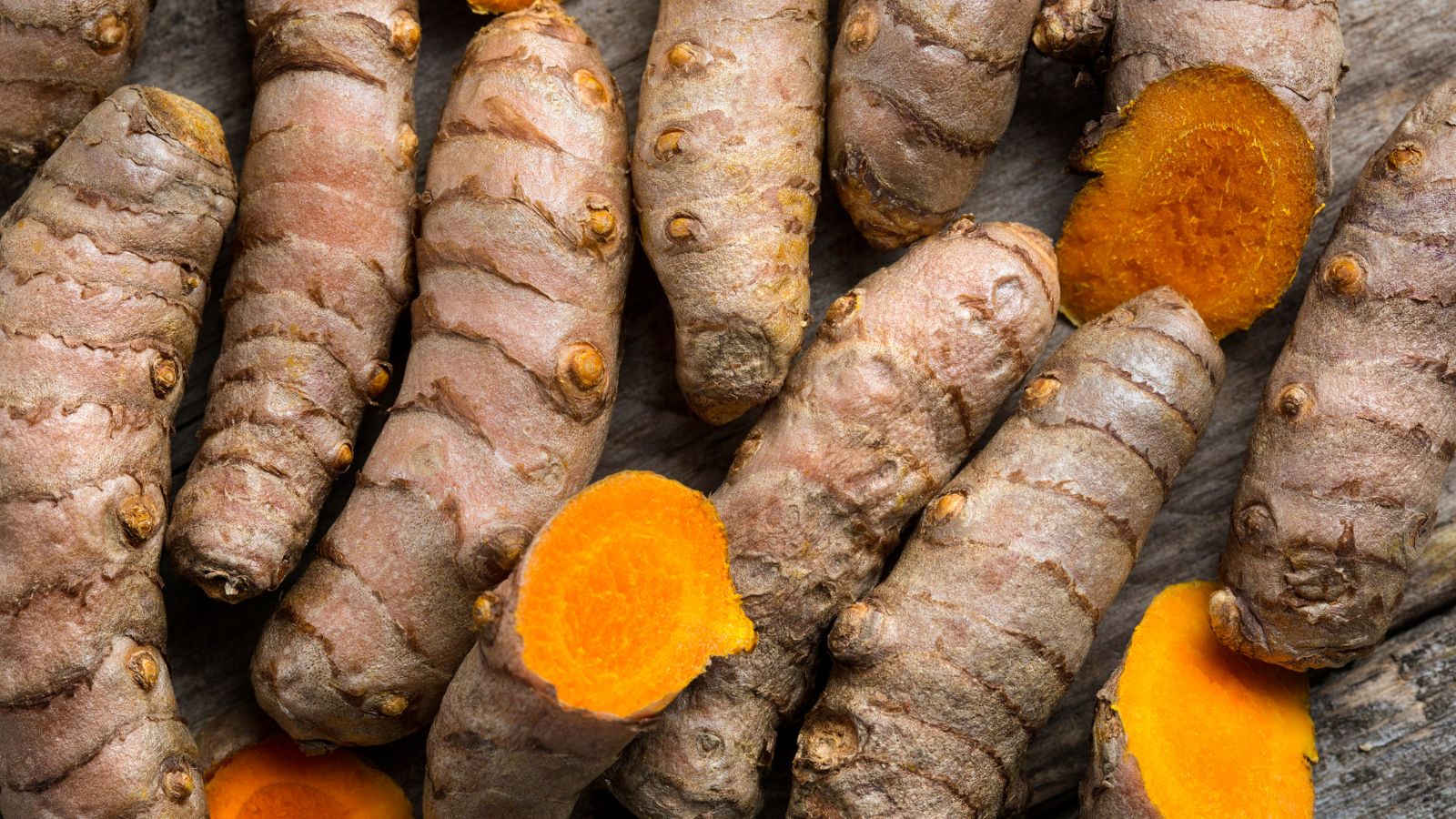 Close-up of sliced turmeric roots showing bright orange interior