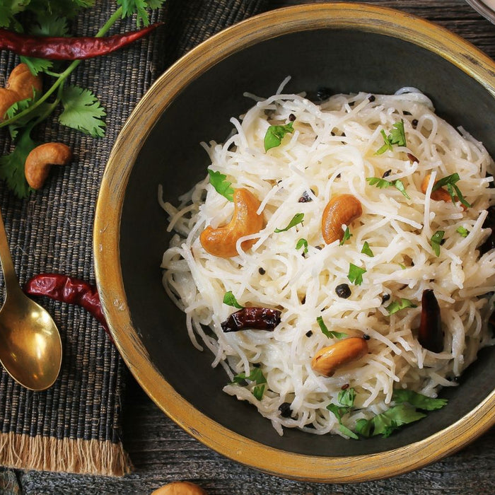 Vermicelli noodles with cashew nuts and spices in a brass bowl.