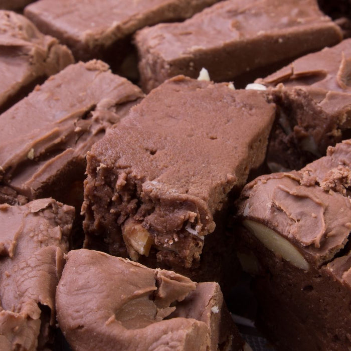 Close-up of rich chocolate fudge squares with visible chunks of nuts