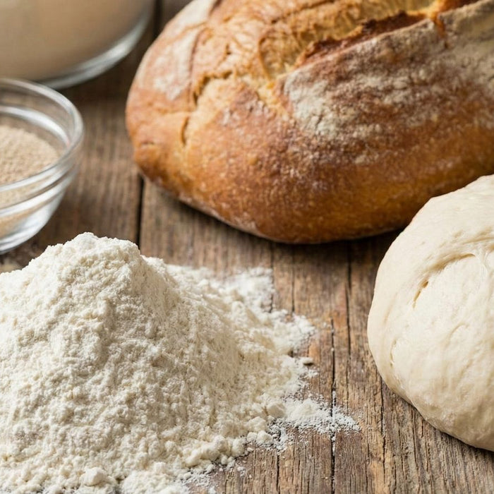 Bread dough, flour, yeast, and baked loaf on rustic wooden table