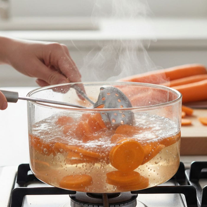 Carrot slices boiling in pot on stovetop during cooking