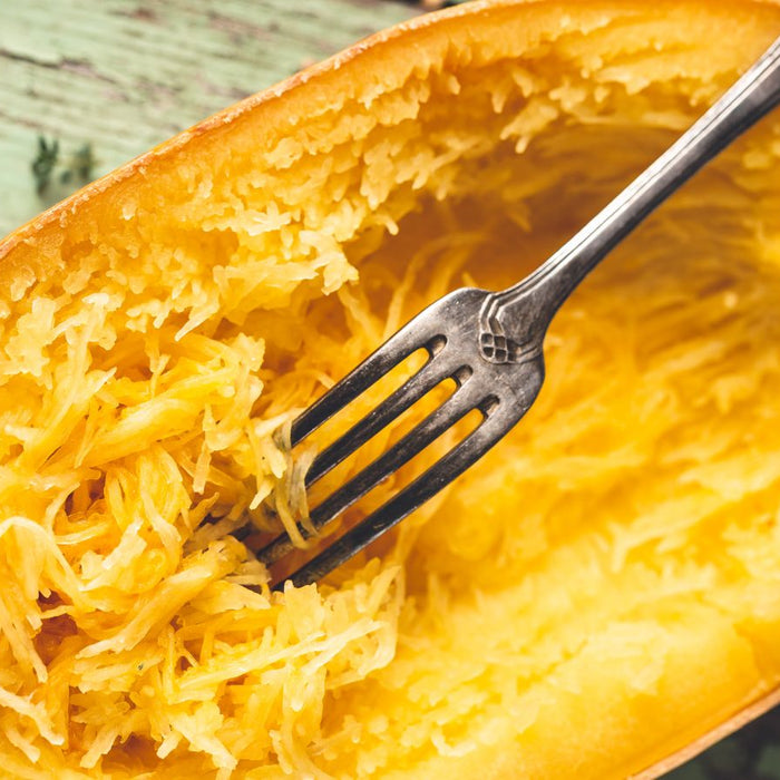 Baked spaghetti squash with fork pulling strands