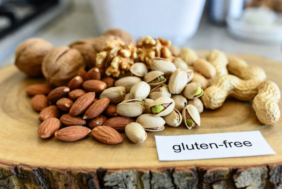 Assorted nuts on wooden board with gluten-free label in kitchen